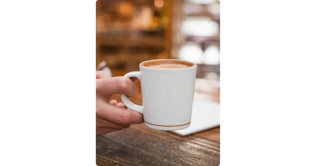 a hand is holding a mug